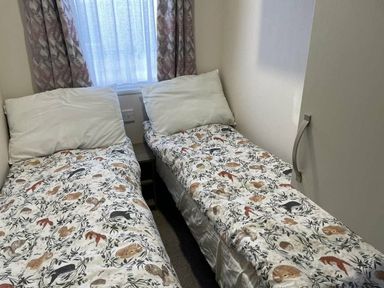 two single beds with patterned bedding in a room at Rockley Park - Holiday Accommodation 19386, Poole