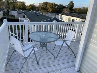 a balcony with a table and two folding chairs at Rockley Park - Holiday Accommodation 19386, Poole