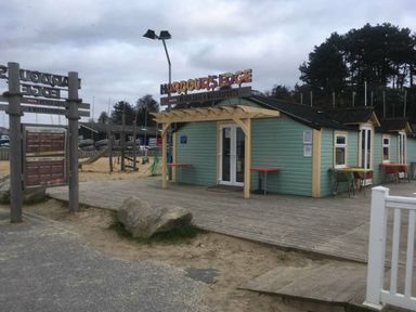 a building with outdoor seating and a sign at Harbour Edge in Poole