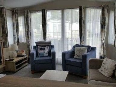 a living room with two armchairs, a sofa, and a table at Pinewoods Holiday Park - Holiday Accommodation 19734 Wells-Next-The-Sea