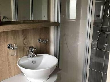 a bathroom with a circular sink and shower enclosure at Pinewoods Holiday Park - Holiday Accommodation 19734 in Wells-Next-The-Sea