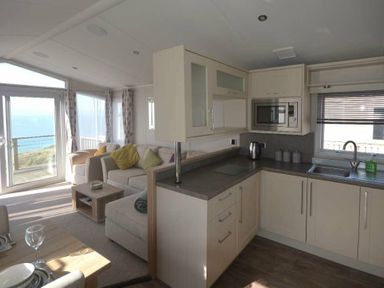a kitchen and living area with sea views at Perran Sands - Holiday Accommodation 19778 in Perranporth