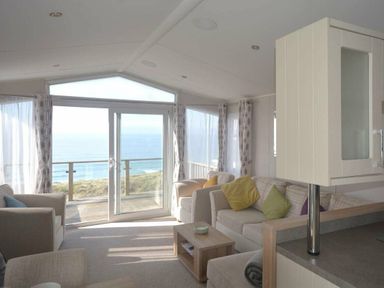 a living room with large windows overlooking the ocean at Perran Sands - Holiday Accommodation 19778, Perranporth