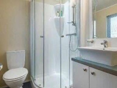 a bathroom with a glass shower enclosure and sink at Hafan y Mor Haven - Holiday Accommodation 19898 in Pwllheli