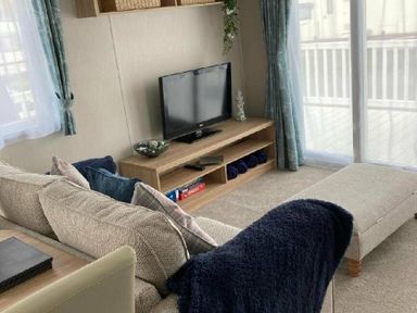 a living room with a television on a shelf and a couch at Lyons Moelfre View - Holiday Accommodation 20226 Talybont