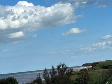 a coastal view with clouds and sea at Sand Le Mere Holiday Village - Holiday Accommodation 20326 in Tunstall