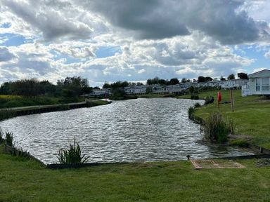 a landscape with a river and mobile homes at Sand Le Mere Holiday Village - Holiday Accommodation 20326 Tunstall