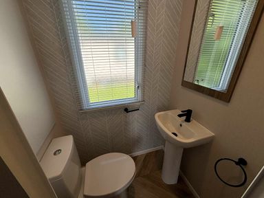 a small bathroom with a toilet and sink at Hafan y Mor Haven - Holiday Accommodation 20481 Pwllheli