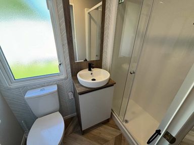a bathroom with a toilet, sink, and shower at Hafan y Mor Haven - Holiday Accommodation 20481 in Pwllheli
