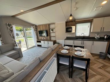 a living room with a dining area and open kitchen at Hafan y Mor Haven - Holiday Accommodation 20481 in Pwllheli