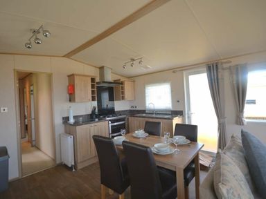 a kitchen and dining area with a table set for meals at Perran Sands - Holiday Accommodation 20514, Perranporth
