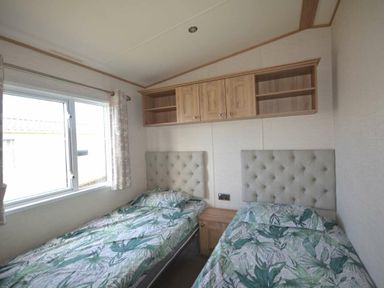a bedroom with two single beds and a window at Perran Sands - Holiday Accommodation 20514 in Perranporth