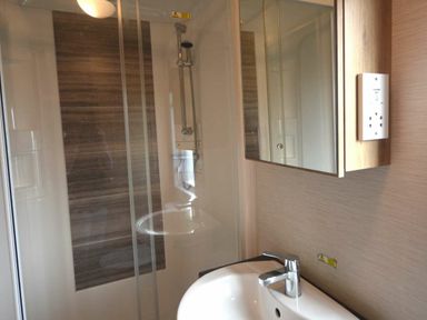 a bathroom featuring a shower, a sink, and a mirror at Perran Sands - Holiday Accommodation 20514 in Perranporth