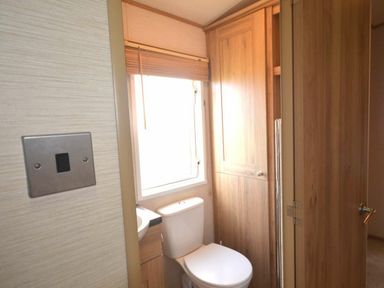 a bathroom with a toilet, sink, and window at Perran Sands - Holiday Accommodation 20514, Perranporth