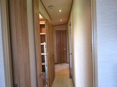 a hallway with wooden doors and a closet at Perran Sands - Holiday Accommodation 20514 in Perranporth