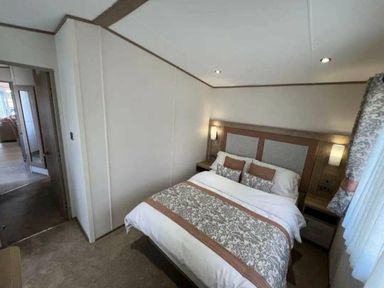 a bedroom with a bed and bedside tables at Lakeland Leisure Park - Holiday Accommodation 20788 in Flookburgh