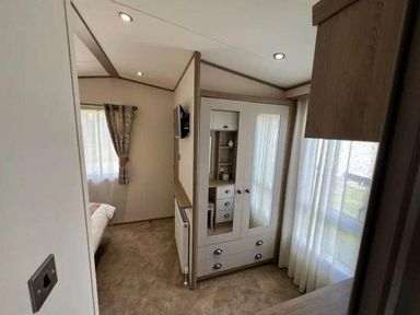 a bedroom with a wardrobe and a bed at Lakeland Leisure Park - Holiday Accommodation 20788, Flookburgh