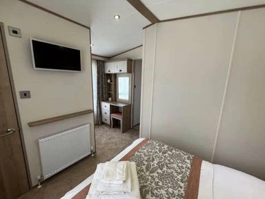 a bedroom with a bed and wall-mounted TV at Lakeland Leisure Park - Holiday Accommodation 20788 Flookburgh