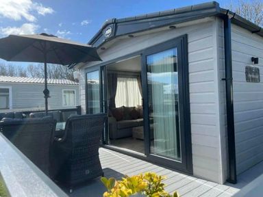 a terrace area with outdoor seating and large windows at Lakeland Leisure Park - Holiday Accommodation 20788, Flookburgh