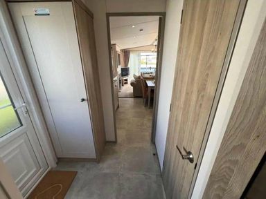 a hallway with doors on either side leading to a living area at Lakeland Leisure Park - Holiday Accommodation 20788, Flookburgh