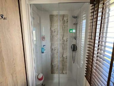 a shower enclosure with glass doors and tiled wall at Lakeland Leisure Park - Holiday Accommodation 20788 in Flookburgh