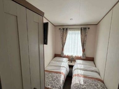 a bedroom with two single beds and a window at Lakeland Leisure Park - Holiday Accommodation 20788, Flookburgh