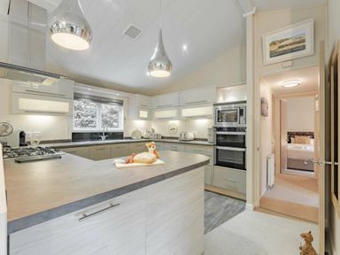 a kitchen with modern appliances and an island at Kelling Heath Holiday Park - Holiday Accommodation 20952 in Weybourne
