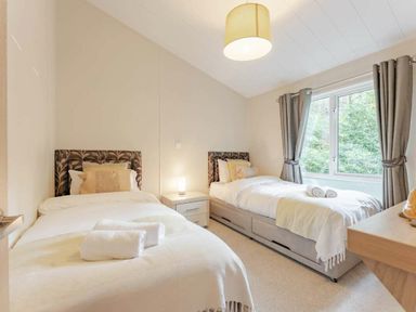 a bedroom with two single beds and a window at Kelling Heath Holiday Park - Holiday Accommodation 20952 Weybourne