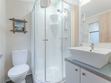 a bathroom with a shower, toilet, and sink at Kelling Heath Holiday Park - Holiday Accommodation 20952 in Weybourne