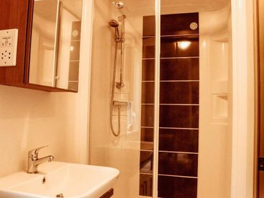 a bathroom with a shower cubicle and a sink at Kelling Heath Holiday Park - Holiday Accommodation 21026 Kelling Heath