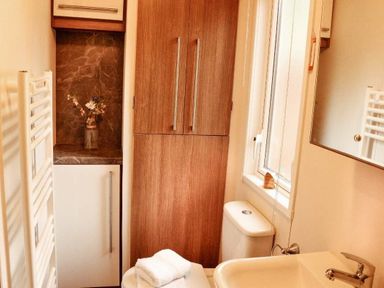 a bathroom with a shower, sink, and storage cabinet at Kelling Heath Holiday Park - Holiday Accommodation 21026, Kelling Heath