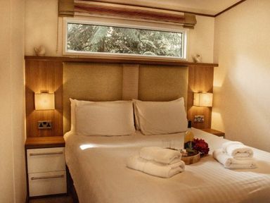 a bedroom with a double bed and bedside lamps at Kelling Heath Holiday Park - Holiday Accommodation 21026, Kelling Heath