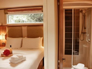 a bedroom with a double bed and an attached shower area at Kelling Heath Holiday Park - Holiday Accommodation 21026 in Kelling Heath