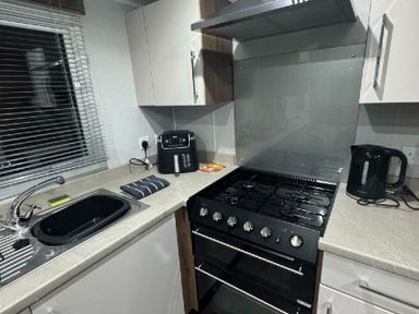 a kitchen with a gas stove, kettle, and sink at Butlins Skegness - Holiday Accommodation 21028 in Skegness