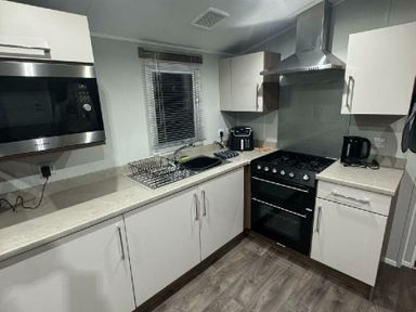 a kitchen with a microwave, oven, sink, and countertop at Butlins Skegness - Holiday Accommodation 21028, Skegness