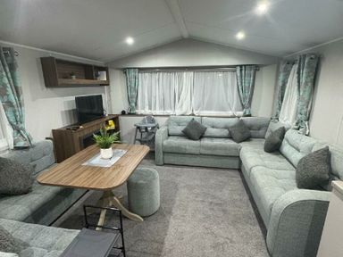 a living room with a sofa set, coffee table, and television at Butlins Skegness - Holiday Accommodation 21028 in Skegness
