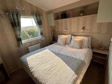 a bedroom with a double bed and shelves at Perran Sands - Holiday Accommodation 21088 in Perranporth
