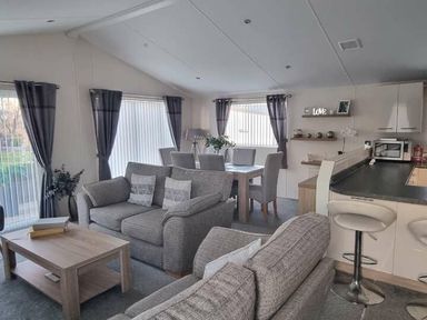 a living room with a dining area and kitchen in Presthaven Beach Resort - Holiday Accommodation 21358, Prestatyn
