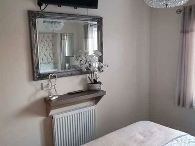 a bedroom with a mirror and a plant on a shelf at Presthaven Beach Resort - Holiday Accommodation 21358 in Prestatyn