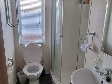 a bathroom with a shower, toilet, and sink at Presthaven Beach Resort - Holiday Accommodation 21358 in Prestatyn