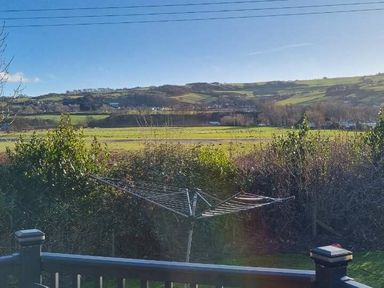 a view of rolling hills and fields with a clothesline in the foreground at Presthaven Beach Resort - Holiday Accommodation 21358, Prestatyn