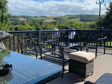a deck area with seating and a view of hills at Presthaven Beach Resort - Holiday Accommodation 21358, Prestatyn