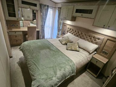 a bedroom with a large bed and wooden furniture at Tattershall Lakes Country Park - Holiday Accommodation 21501, Tattershall