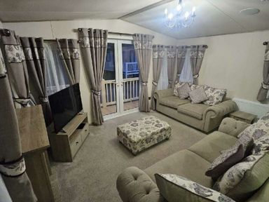 a living room with a sofa, armchair, and curtains at Tattershall Lakes Country Park - Holiday Accommodation 21501 in Tattershall