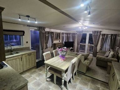 a living room and dining area with a table, chairs, and a sofa at Tattershall Lakes Country Park - Holiday Accommodation 21501 in Tattershall