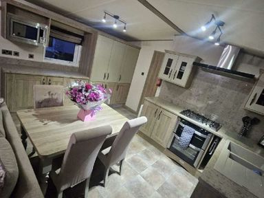 a kitchen with a dining table and flowers on it at Tattershall Lakes Country Park - Holiday Accommodation 21501, Tattershall