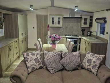 a kitchen area with a dining table and sofa at Tattershall Lakes Country Park - Holiday Accommodation 21501 in Tattershall