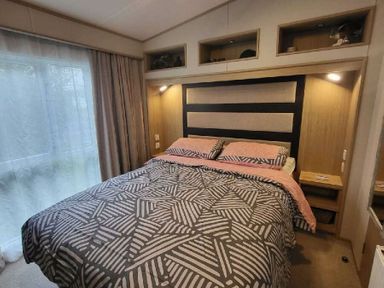 a bedroom with a bed featuring a patterned duvet and headboard at Swanage Bay View - Holiday Accommodation 21567 in Swanage