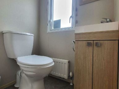a bathroom with a toilet and sink cabinet at Swanage Bay View - Holiday Accommodation 21567 in Swanage