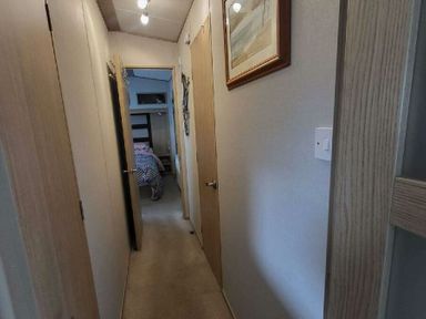 a hallway with doors on each side leading to rooms at Swanage Bay View - Holiday Accommodation 21567 in Swanage